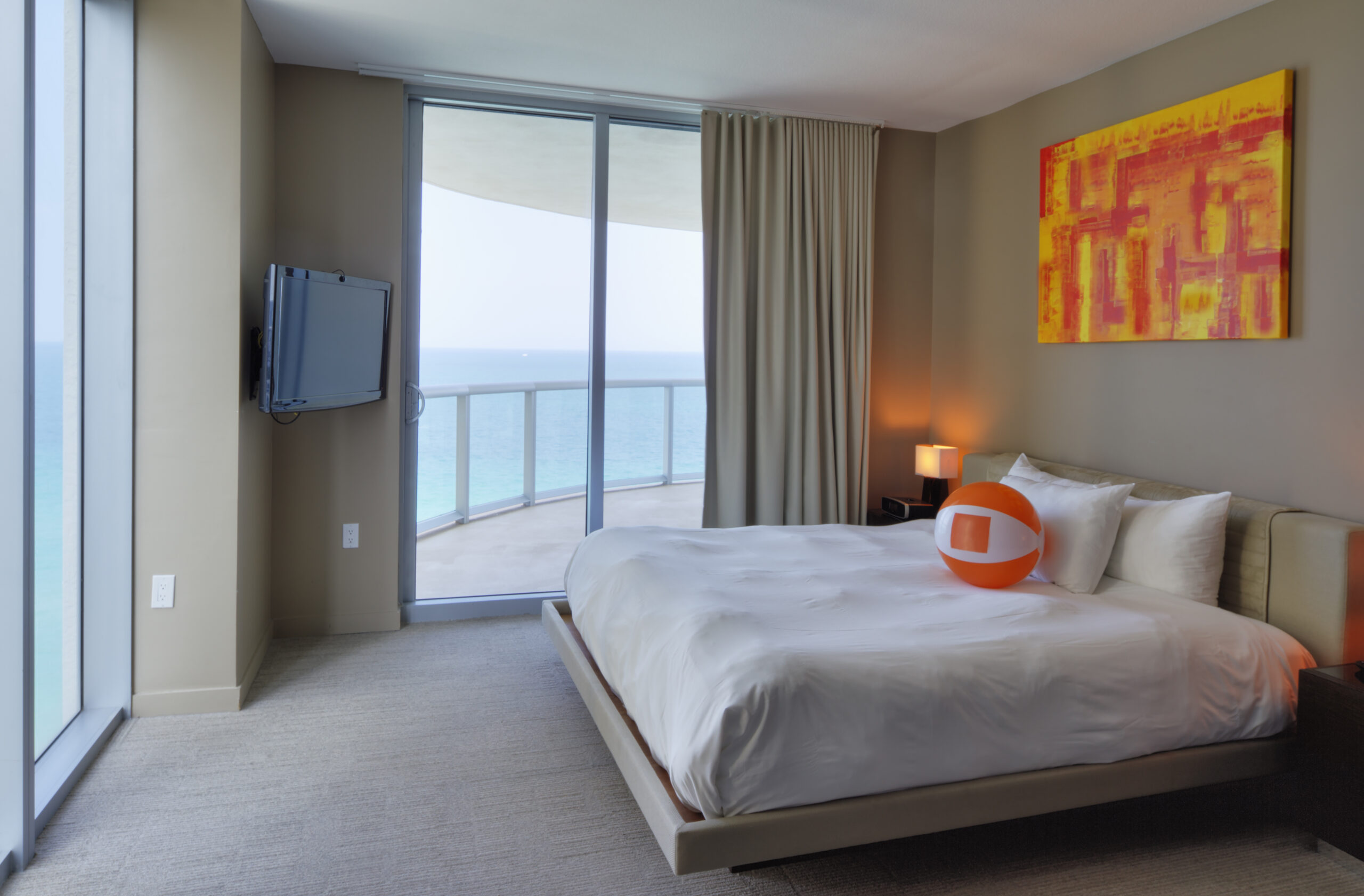 Beach ball on bed in hotel room